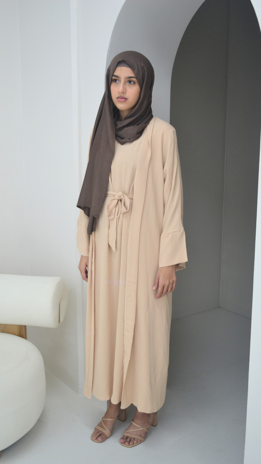 front of a cream everyday 3pc abaya 